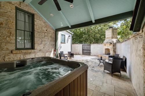 a hot tub in a patio with a table and chairs at Blacksmith Quarters in Fredericksburg