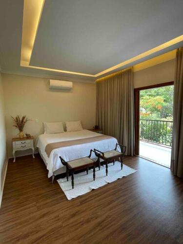 ein Schlafzimmer mit einem großen Bett und einem großen Fenster in der Unterkunft Casa Jacarandá in Alto Paraíso de Goiás