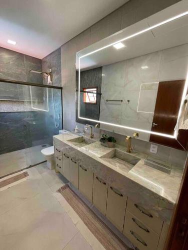 ein Badezimmer mit zwei Waschbecken und einer Toilette und einem Spiegel in der Unterkunft Casa Jacarandá in Alto Paraíso de Goiás