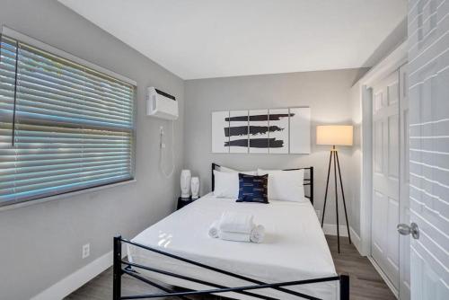 Dormitorio blanco con cama y ventana en Rustic Retreats Spacious 1BR For 4 guests In The Heart of Fort Lauderdale, en Fort Lauderdale