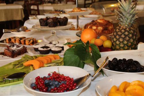 a table topped with plates of fruit and desserts at Hotel Aganoor in Castiglione del Lago