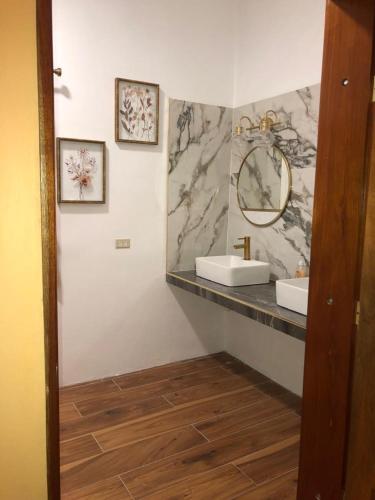 bagno con 2 lavandini e specchio di Banyan Rose Room 4 a Orange Walk Town