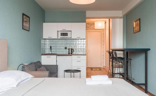a bedroom with a white bed and a kitchen at Kudebi apartments, Twins new Gudauri in Gudauri