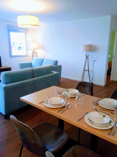 un salon avec une table et un canapé dans l'établissement Zenao Appart'hôtels Boulogne-sur-Mer - La Rose des Vents, à Boulogne-sur-Mer