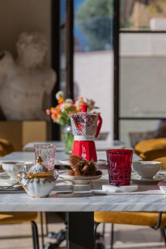 a table with plates and cups and a vase on it at Tenuta Zamparina in Montignoso