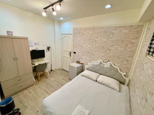 a bedroom with a bed and a brick wall at Fengchia Oslo in Taichung