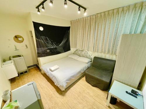 a small room with a bed and a chair at Fengchia Oslo in Taichung