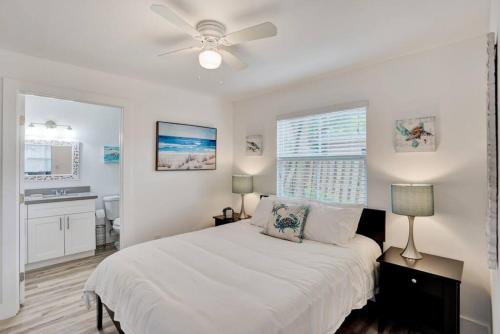 um quarto branco com uma cama e uma ventoinha de tecto em Full Beach Chalet One block from the Beach em Pompano Beach