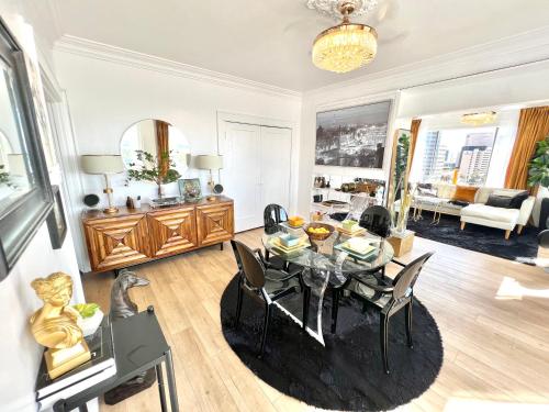 a living room with a dining room table with chairs at Your Penthouse Ocean view with City lights and Queen Mary too in Long Beach