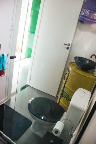 a bathroom with a toilet and a sink at Casa Container á 3minutos da Lagoa in Tapes