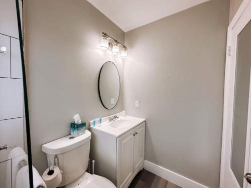 een badkamer met een toilet, een wastafel en een spiegel bij Pionciana Getaway 1BR Apartment Near FLL Airport in Fort Lauderdale