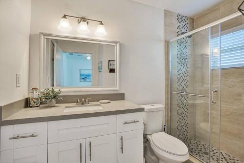 Un baño con inodoro, lavabo y ducha. en Beach Getaway One Block from the Beach, en Pompano Beach