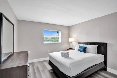 a white bedroom with a large bed and a window at Pionciana Getaway 1BR Apartment Near FLL Airport in Fort Lauderdale