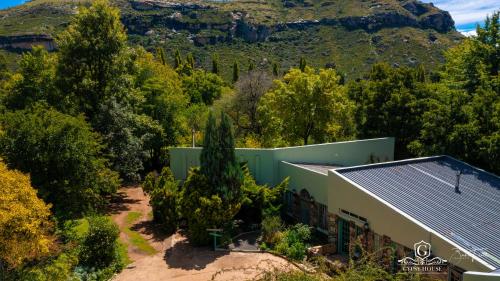 an aerial view of a house with trees and a mountain at Gypsy Guest House Clarens in Clarens