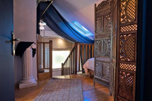 une porte ouverte menant à une chambre avec un lit et un rideau bleu dans l'établissement UnSejourAMetz - Le mille et une nuits, à Metz