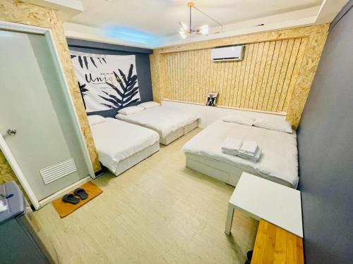 a small room with two beds and a table at Fengchia Oslo in Taichung