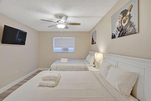 a bedroom with two beds and a flat screen tv at The Oceans Cozy 2BR Apartment in Victoria Park in Fort Lauderdale