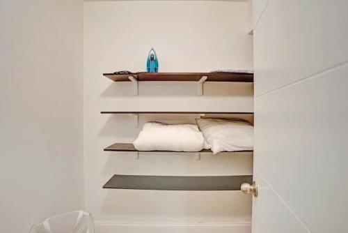 a bathroom with white walls and shelves with towels at The Oceans Cozy 2BR Apartment in Victoria Park in Fort Lauderdale