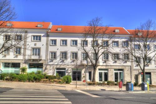 a large white building with a red roof at Hotel Jeronimos 8 in Lisbon