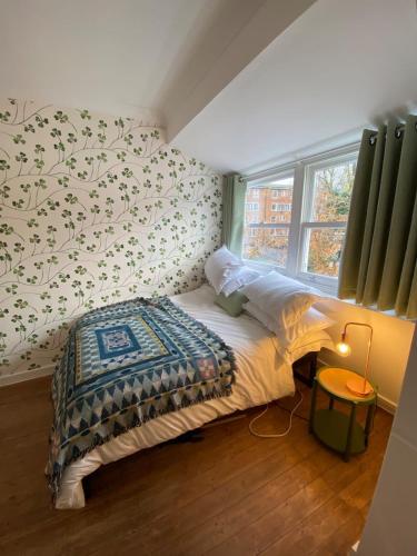 Modern 1BD Farmhouse-Style Flat - Dalston! في لندن: غرفة نوم بسرير ونافذة