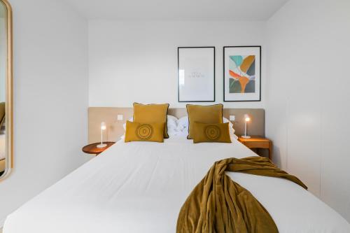 um quarto com uma grande cama branca com almofadas amarelas em Agaete Penthouse Bliss Views em Puerto de las Nieves