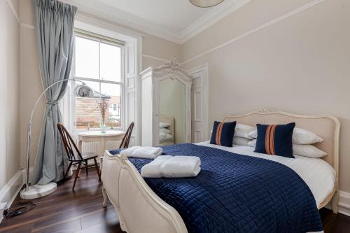 1 dormitorio con cama, escritorio y ventana en Stylish Victorian Apartment's close to the Botanical gardens, Free parking! en Edimburgo