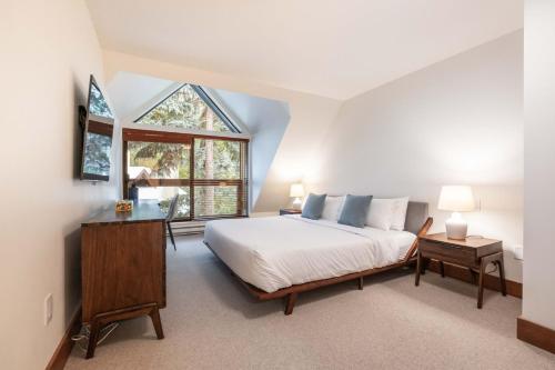 a bedroom with a white bed and a window at Snowberry by Outpost Whistler in Whistler