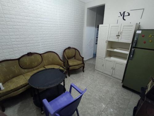 een kamer met een tafel en stoelen en een koelkast bij Victoria Hostel in Alexandrië