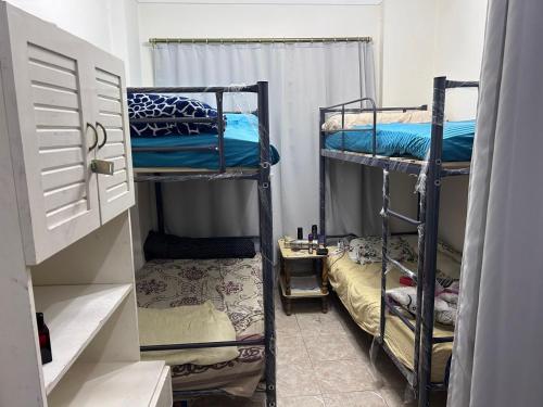 a small room with two bunk beds and a door at Victoria Hostel in Alexandria