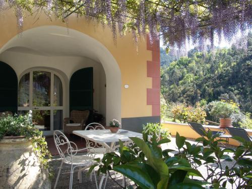 a patio with a table and chairs in a building at Villanova Apartments - Nature & Wellness in Levanto