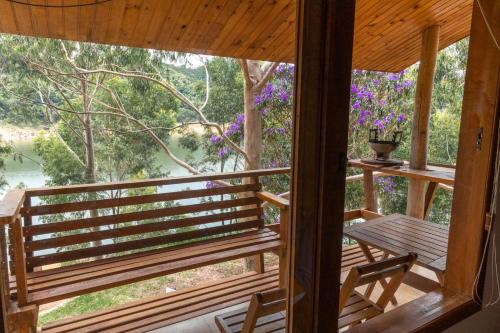 uitzicht vanaf de veranda van een hut met een tafel en stoelen bij Casa INTI Refugio Romantico Pague duas noites minimo e a terceira e brinde, menos feriados in Natividade da Serra