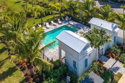 una vista aérea de una casa con piscina y palmeras en LUX Townhome 15m 2 Beach & 5th Ave! EV Charger!, en Naples
