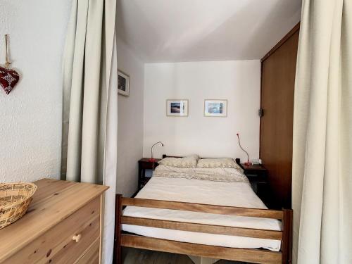 ラ・トゥッスイールにあるStudio La Toussuire, 1 pièce, 5 personnes - FR-1-416-128の小さなベッドルーム(ベッド1台、木製キャビネット付)