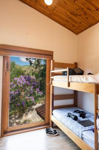 a bunk bed room with a view of a garden at Casa INTI Refugio Romantico Pague duas noites minimo e a terceira e brinde, menos feriados in Natividade da Serra