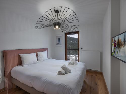 une chambre avec un grand lit avec des serviettes dessus dans l'établissement Appartement moderne 6 pers proche pistes avec parking, casier à ski, balcon - FR-1-563-140, à Courchevel