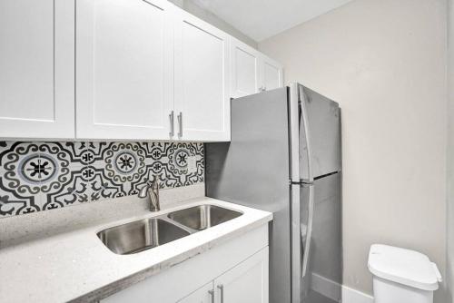 a kitchen with a sink and a refrigerator at Pionciana Getaway 1BR Apartment Near FLL Airport in Fort Lauderdale