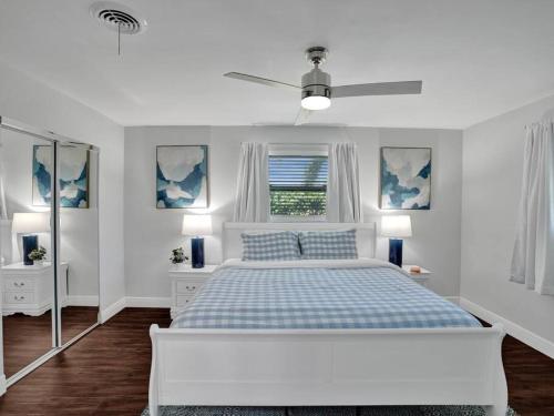 a white bedroom with a bed and a ceiling fan at Poolside Paradise Spacious 3BR Haven near Pompano Beach in Pompano Beach