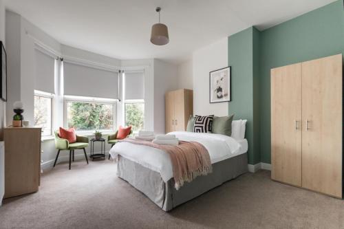 um quarto com uma cama grande e paredes verdes em Beautiful 3BR Flat with Desks and Fast Wi-Fi em Londres