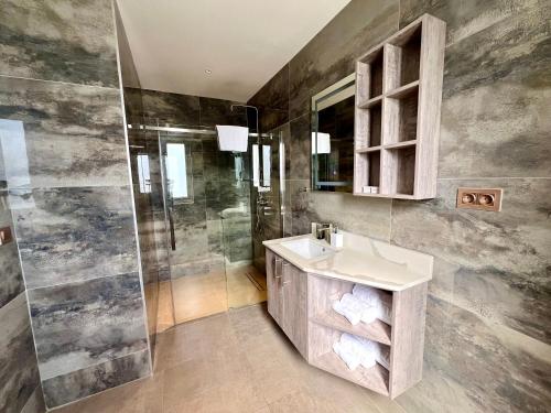 a bathroom with a sink and a shower at Xanadu Apartments at Blue Bay Golf & Beach Resort in Willemstad