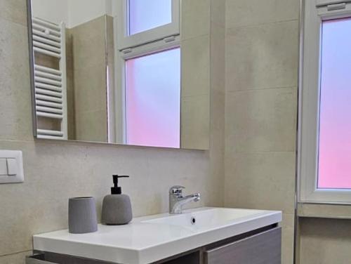 baño con lavabo y espejo y 2 ventanas en LAKE HOUSE CANZO, en Canzo