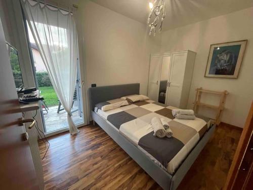 1 dormitorio con cama y ventana grande en Bellissima vicino al lago di Como Lecco climatizzata barbecue, en Suello