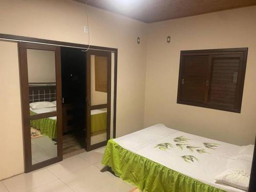 1 dormitorio con cama y espejo en SÍTIO CANTINHO DO SOSSEGO, Casa de campo, pescaria, lareira, jogos de bilhar, area gourmet etc, en Treze de Maio