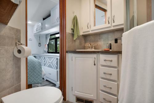 a small bathroom with a toilet and a sink at Tow-tally peachy Atlanta themed Tiny House in Tucker