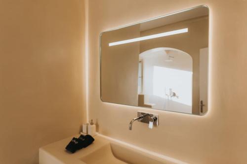 ein Bad mit einem Waschbecken und einem Spiegel in der Unterkunft Private Cliffside Villa "150 meters from the beach" in Mykonos Stadt
