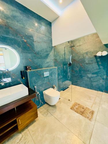 a bathroom with a toilet and a sink and a shower at Misty Wonders in Munnar