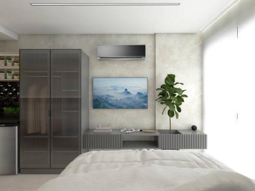カベデロにあるFLAT aconchegante e moderno, 100m do marの白いベッドと壁に絵画が飾られたベッドルーム1室