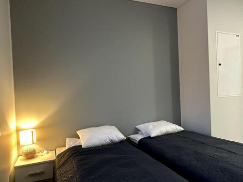 1 dormitorio con 2 camas y mesa con lámpara en Kotimaailma Apartments #3 - viihtyisä kaksio keskustassa, en Seinäjoki