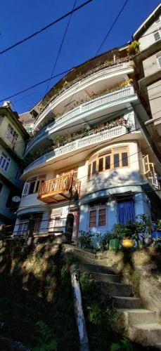 Un grand bâtiment avec des escaliers se trouve juste devant. dans l'établissement BaalaChhen Urban Home Stay, à Gangtok