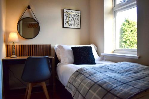 - une chambre avec un lit, un miroir et une chaise dans l'établissement Freeman Hot Tub House, Free Parking, Transport Links, à Longbenton