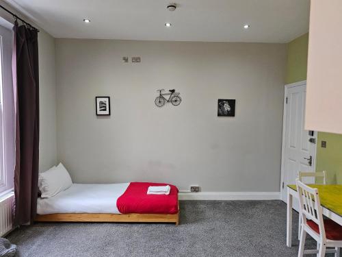 1 dormitorio con 1 cama y una bicicleta en la pared en Spacious Studio in London, en Londres